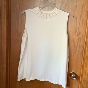 Sleeveless knit turtleneck type sweater with pearls around the neck
